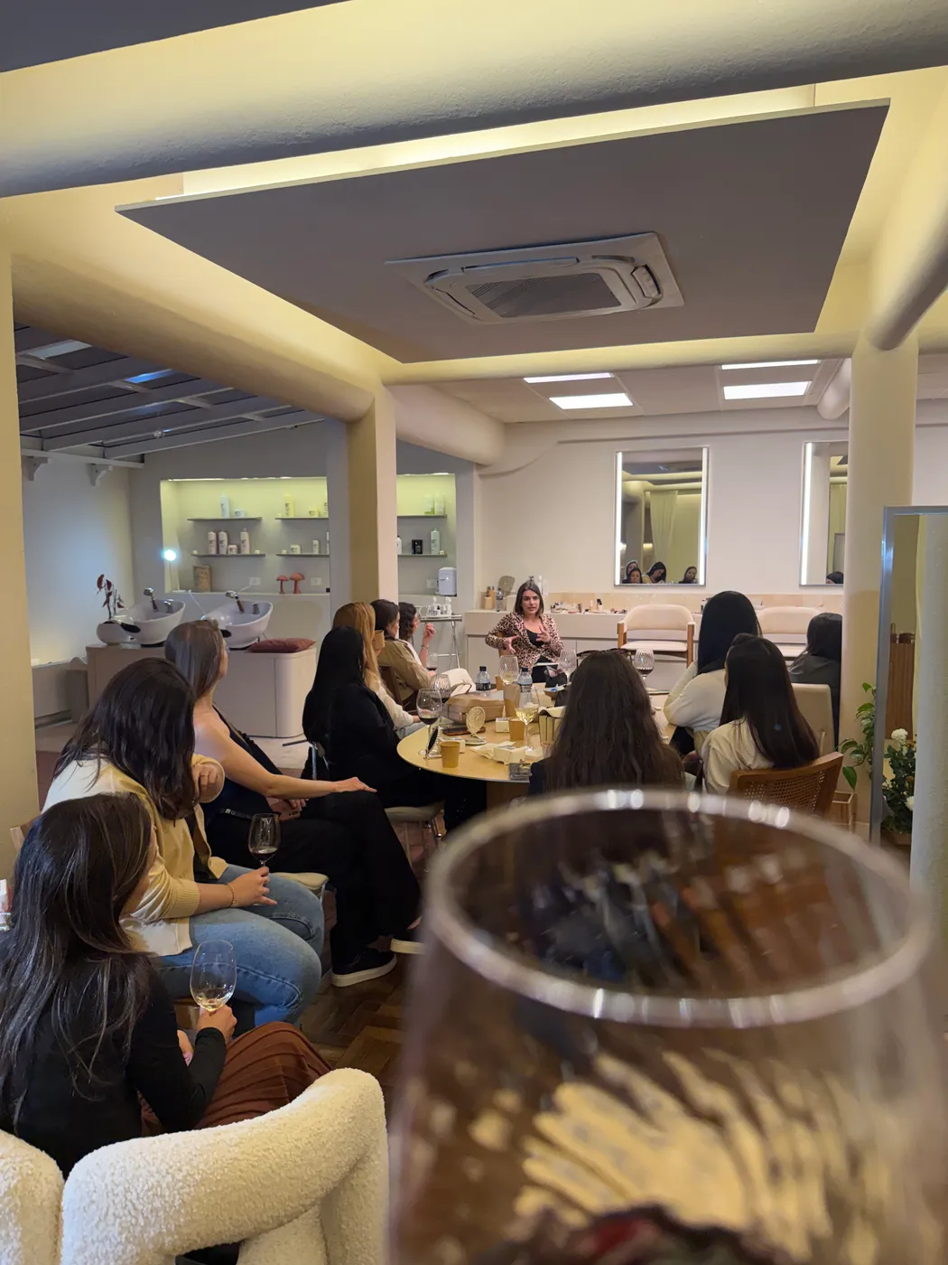 Grupo sentado acompanhando a conversa, taças na mesa