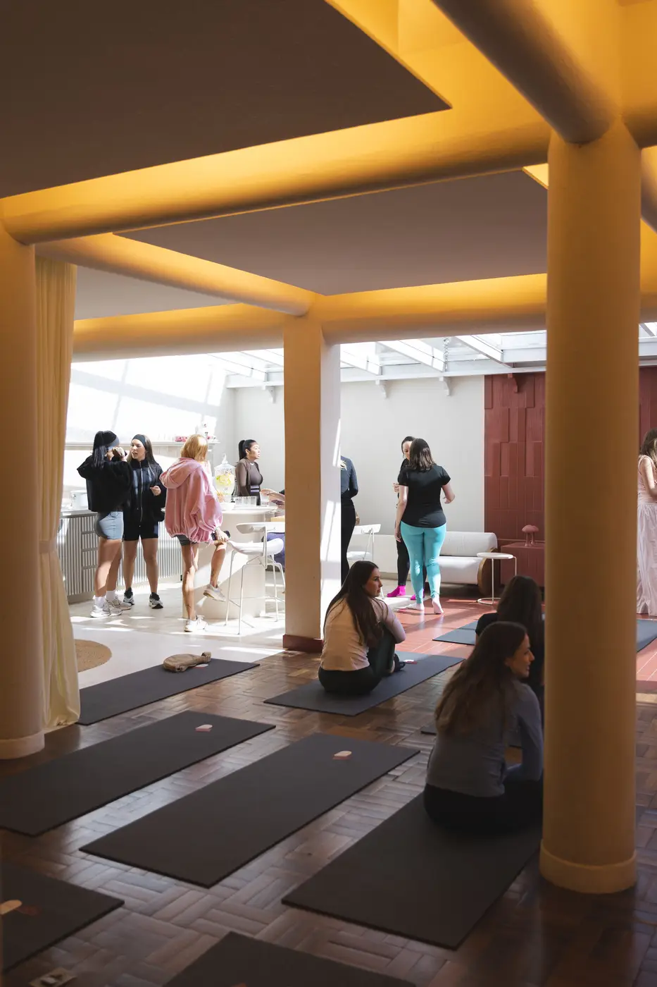 Salão de yoga cheio, tapetes e a turma reunida no Wellness Day