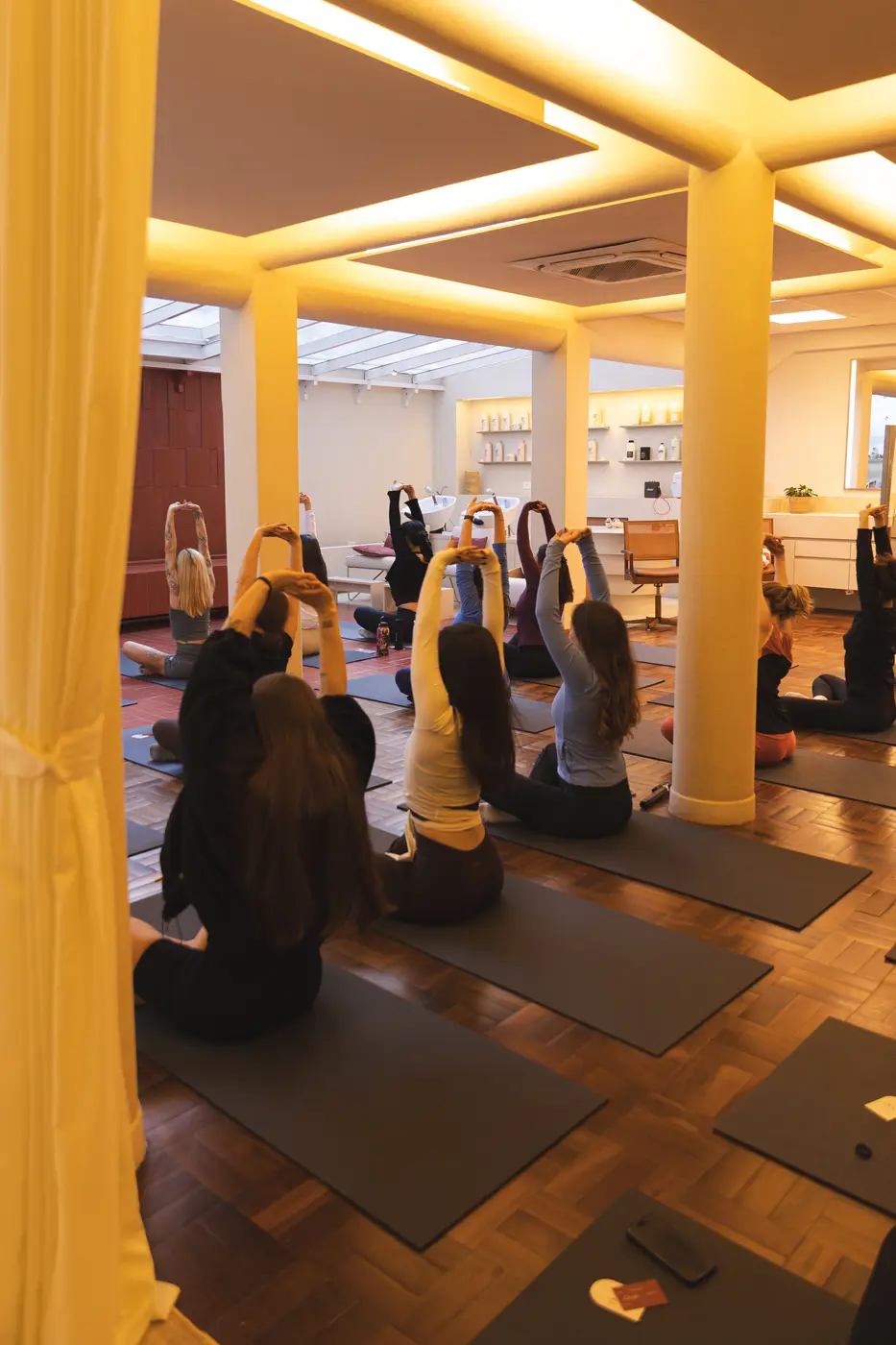 Turma de yoga com os braços erguidos, sob a luz dourada