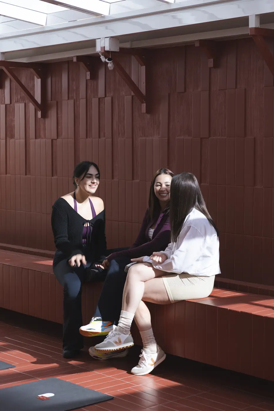 Duas mulheres conversando no banco de tijolinho