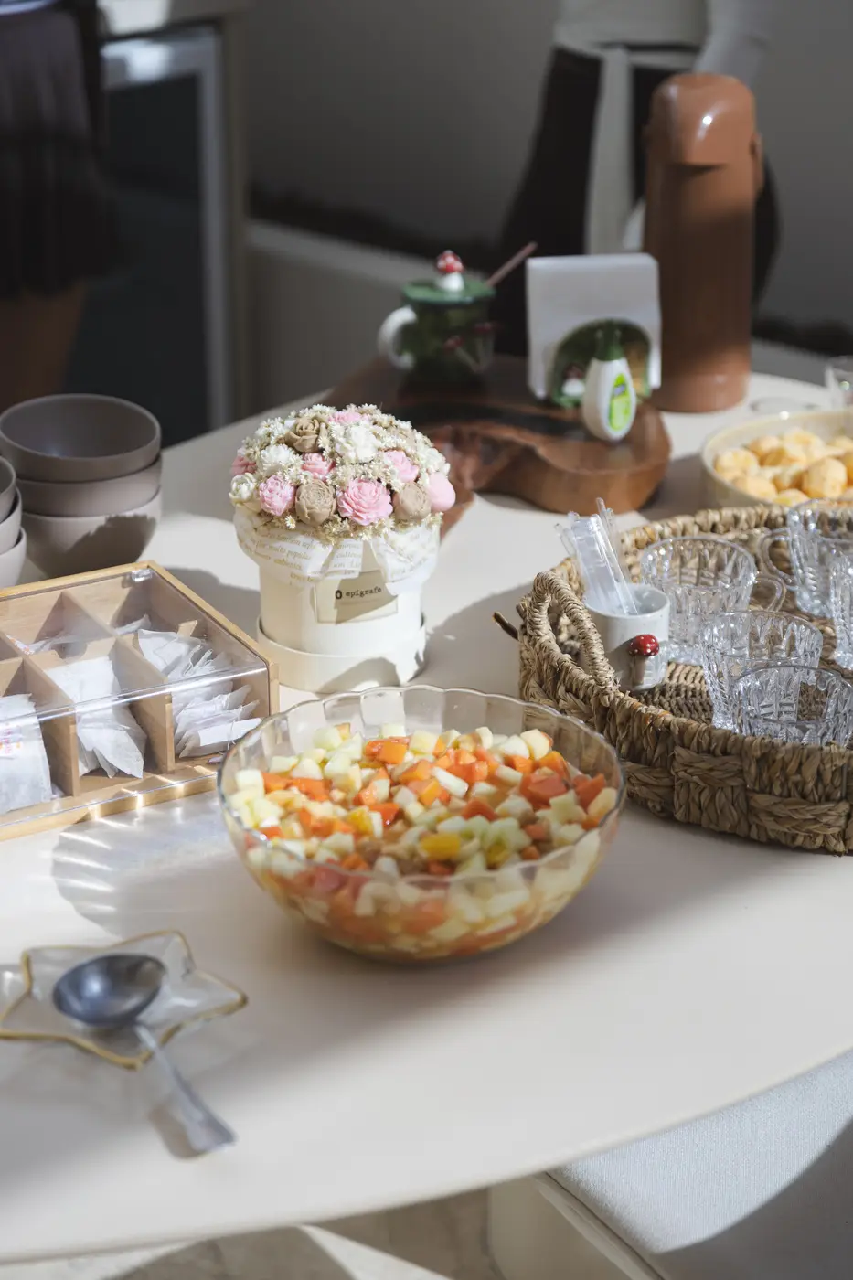 Mesa posta com flores, salada de frutas e comidinhas