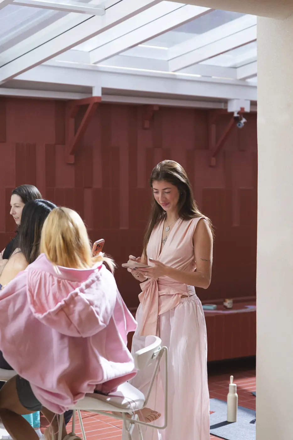 Duas mulheres conversando, uma de roupão rosa